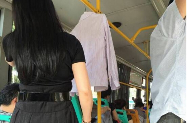 奇葩!武汉女子自带衣架上公交 在车厢内当众晒衣服