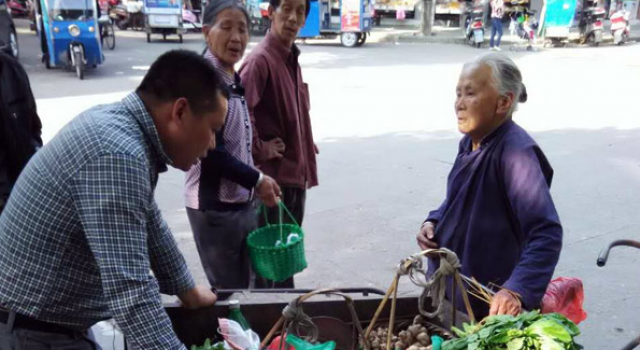 暖！老太卖菜收百元假钞委屈直哭 城管用真钞换下