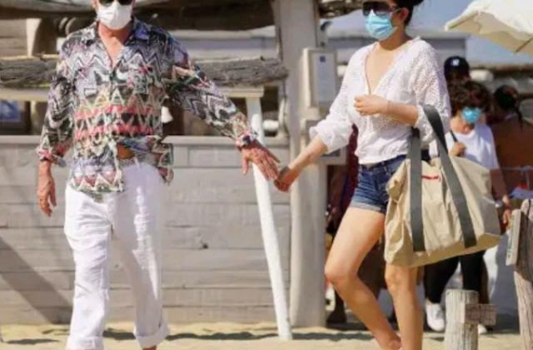 巩俐与老公的沙滩照，穿宽松衣配热裤身材发福，72岁老公很年轻